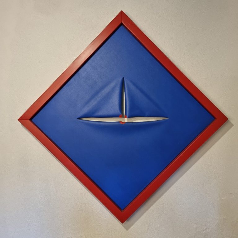 Œuvre d'art géométrique avec un fond bleu, un cadre rouge et une forme en relief.